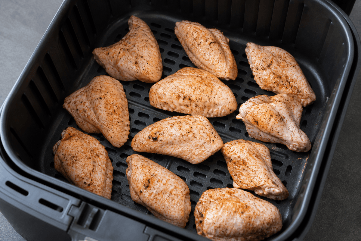 Seasoned wings in a single layer in the air fryer basket