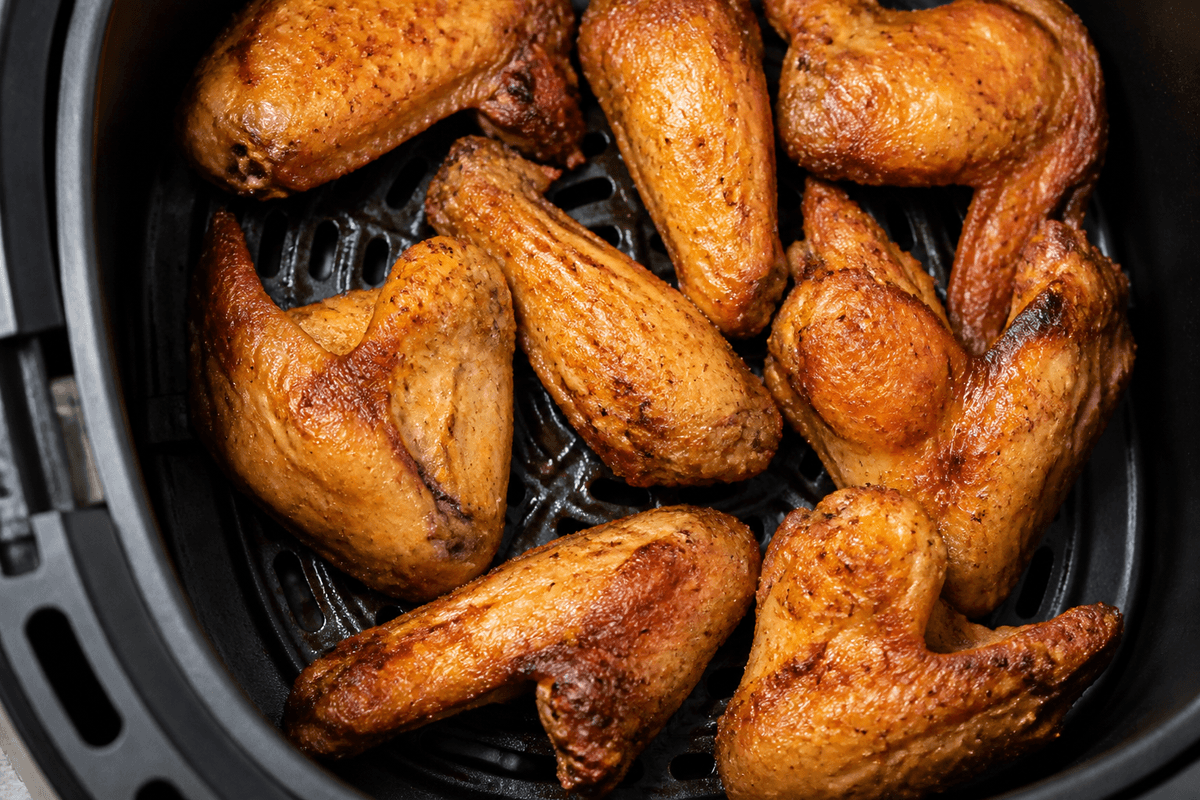 Crispy cooked chicken wings in the air fryer basket
