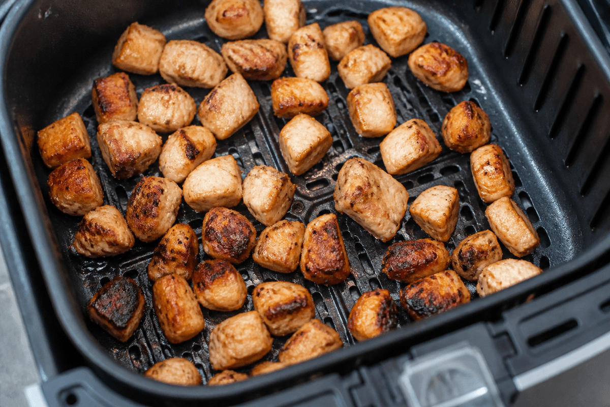 Diced chicken browning in the air fryer basket